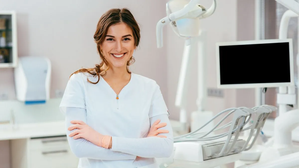 Dentista donna sorridente in studio odontoiatrico moderno